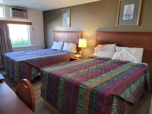 萨德伯里Canadiana Motel的酒店客房设有两张床和窗户。