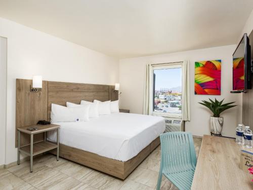 华雷斯城Hotel Mesaluna Near American Consulate的卧室设有一张白色大床和一扇窗户。