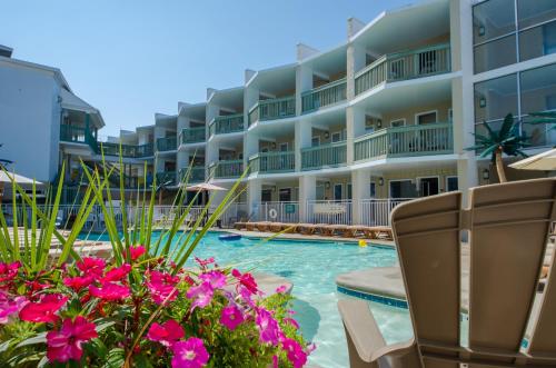 怀尔德伍德阿拉莫阿纳汽车旅馆及套房的一个带游泳池和一些粉红色花卉的度假胜地