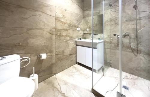 特拉维夫Central Laguardia Hotel的带淋浴、卫生间和盥洗盆的浴室