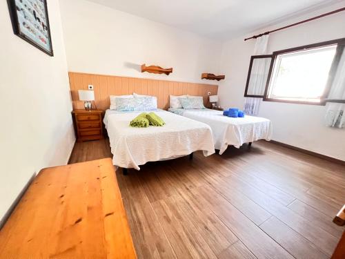 桑坦伊Alojamiento entero Mallorca, Santanyí (S’Amarador)的一间卧室设有两张床,铺有木地板