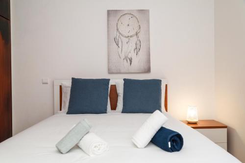纳扎雷Nazaré Landscape的一间卧室配有白色床和蓝色枕头