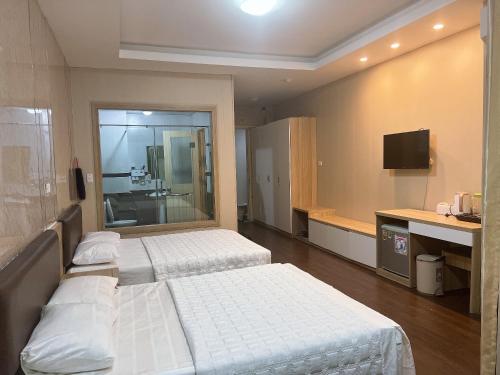 格卢市社Can ho Muong Thanh的酒店客房设有两张床和电视。