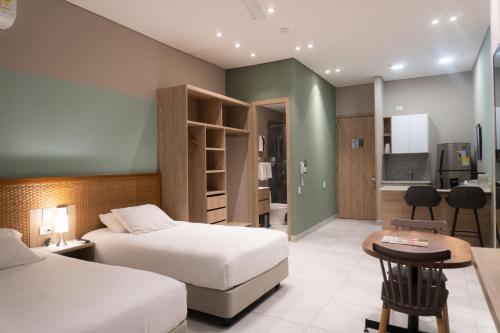伊瓦格FR Hotel的酒店客房带两张床和厨房