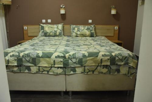 尼什Mps Lux Apartments的一间卧室配有一张带绿色棉被的床
