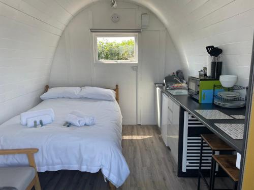 金斯布里奇Cosy Glamping Pod with shared facilities, Nr Kingsbridge and Salcombe的一间卧室配有一张床,上面有两条毛巾