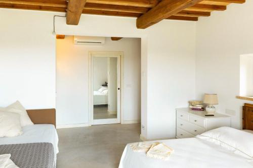 CollazzoneVilla meraviglia的一间白色卧室,配有两张床和镜子