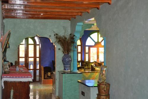 阿加迪尔The Sunrise Villa的客厅拥有蓝色的墙壁和窗户,配有桌子
