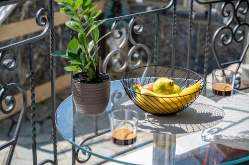 卡瓦拉Seaside Guesthouse的玻璃桌上一碗水果,放上植物