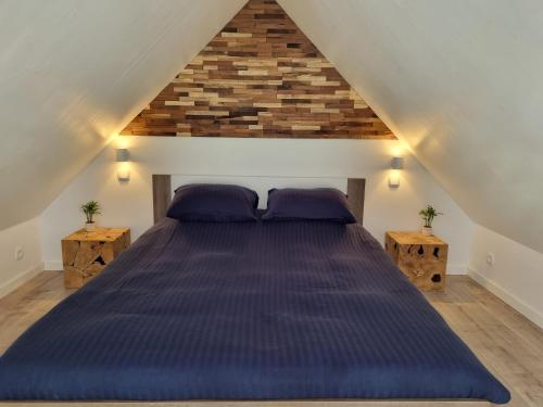 弗利辛恩La vie Est Belle Vlissingen的一间卧室配有一张带紫色枕头的大床