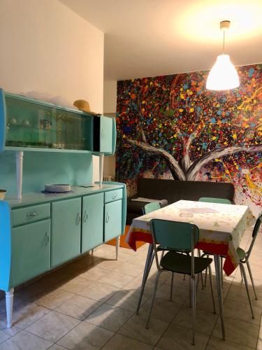 CandeloL’Albero Colorato的厨房配有桌子,墙上挂有绘画作品