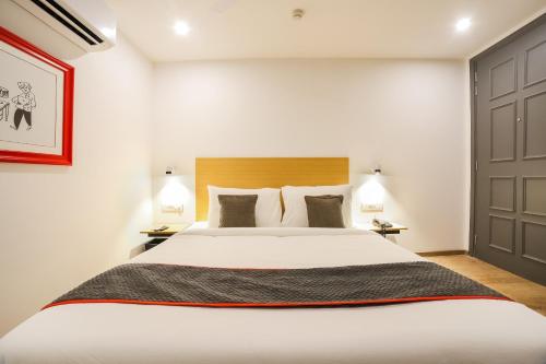 古尔冈Townhouse Near Appu Ghar的一间卧室配有一张带两盏灯的大型白色床。