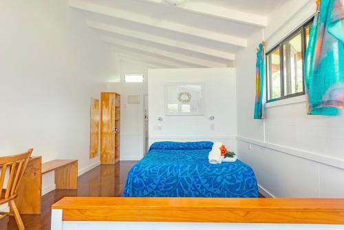 拉罗汤加Aroa Beachside Resort的一间位于客房内的蓝色床卧室