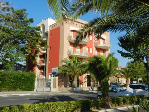 阿尔巴·阿德里亚蒂卡Residence Xenia的一座红色的建筑,前面有棕榈树