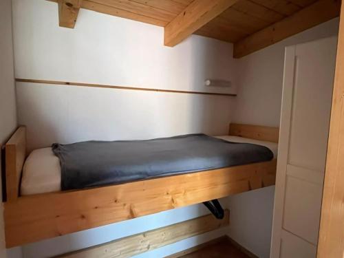克吕茨Cozy Apartment in Klutz Germany with a Lovely Garden的小房间设有一张小床和木制天花板