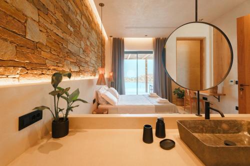 伊奥斯乔拉Villa Mirabilis的一间带水槽和镜子的浴室以及一间卧室