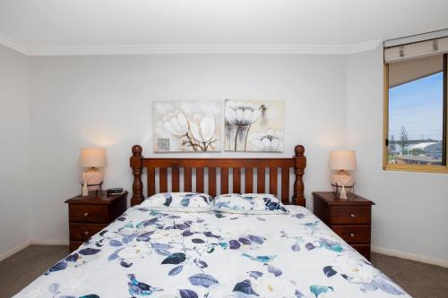 麦夸里港Riviera 306的一间卧室配有一张床和两个带灯的床头柜