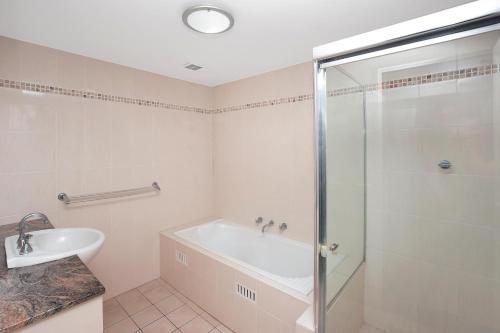 麦夸里港Riviera 306的带淋浴、浴缸和盥洗盆的浴室