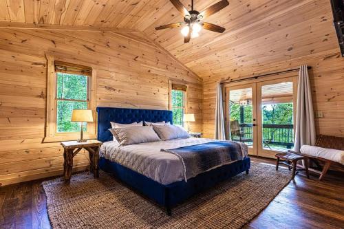蓝岭Luxe Family Cabin 8 min to Downtown Blue Ridge的一间卧室设有蓝色的床和木墙