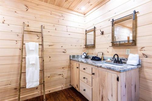 蓝岭Luxe Family Cabin 8 min to Downtown Blue Ridge的一间带水槽和木墙的浴室