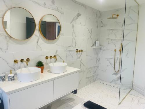 MilltownCountry View House的白色的浴室设有2个水槽和2面镜子