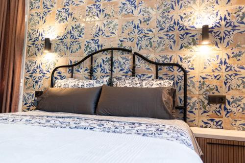 贝纳尔马德纳Villa Yanna的一间卧室配有蓝色和白色壁纸的床