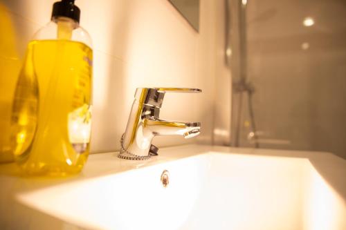 毕尔巴鄂Apartamentos Lidar的浴室水槽旁边设有黄色肥皂瓶