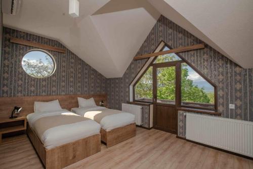 IkaltoChateau Orberi的一间卧室设有两张床和大窗户