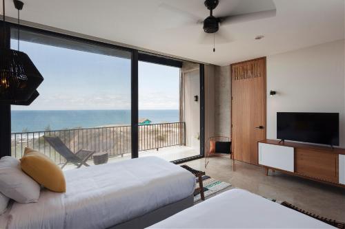 曼塔Eolia Sustainable Design Hotel的卧室设有海景大窗户