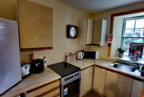 奥克尼Studio in the heart of Kirkwall的厨房配有水槽和炉灶 顶部烤箱