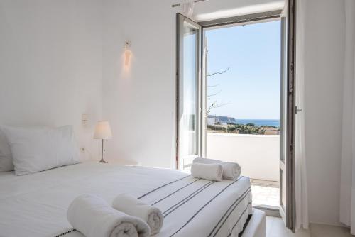 圣玛丽亚Aeraki Villas的卧室设有一张白色大床和大窗户