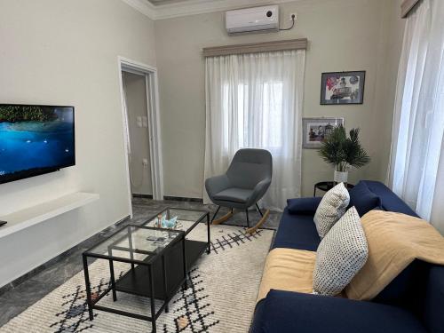 卡利诺岛Irene's house的客厅配有蓝色的沙发和电视