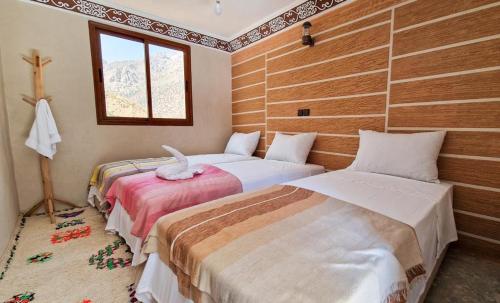 伊姆利尔Toubkal Views的一间卧室设有两张床和窗户。