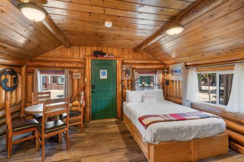 西黄石The Bucking Moose的小木屋内的卧室,配有一张床和一张书桌