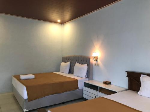 BatukliangBello Bungalow的酒店客房设有两张床和一张桌子。