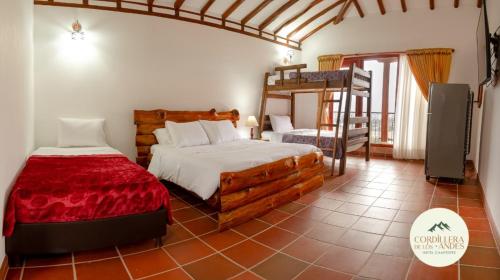 莱瓦镇Hotel Campestre Cordillera de los Andes的一间卧室配有两张床和一张双层床。