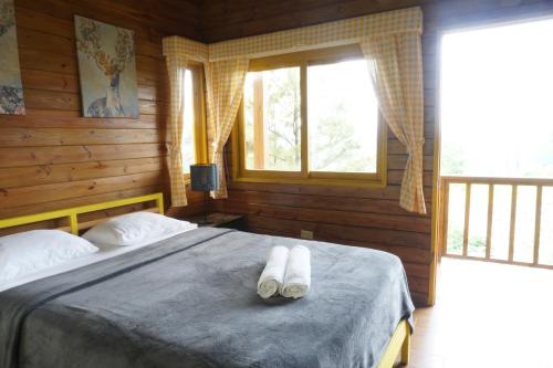 哈拉瓦科阿The Woods By Celebration的一间卧室配有一张床,上面有两条毛巾