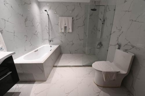 ApalengJ&V Hotel and Resort的白色的浴室设有浴缸、卫生间和水槽。