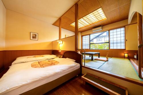 由布市雅瓦拉其佐藤雅多亚酒店的一间卧室设有一张大床和一个窗户。