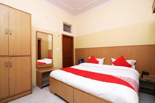 阿里格尔OYO 24103 AKBAR PALACE的一间卧室配有一张大床和镜子