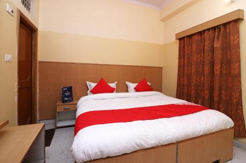 阿里格尔OYO 24103 AKBAR PALACE的一间卧室配有一张带红色枕头的大床