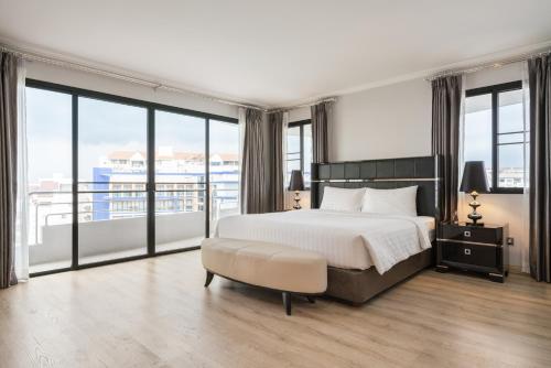 南芭堤雅Sirin Exclusive Hotel and Residence的一间卧室设有一张大床和大窗户