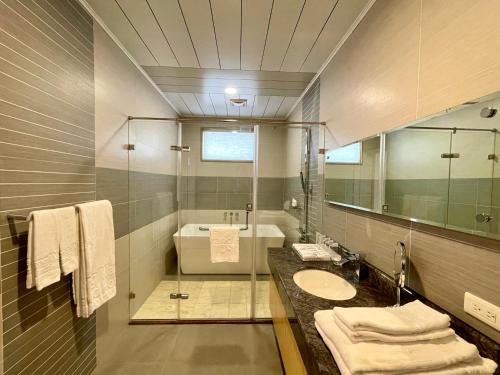埔里承万尊爵渡假酒店的一间带水槽、浴缸和镜子的浴室