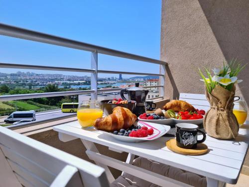 索林Luxury apartment Salona的阳台上的桌子上摆着早餐食品和饮料