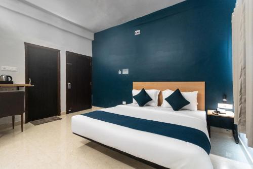 KhandagiriNamaskar Silverkey的一间卧室设有一张蓝色墙壁的大床