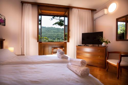 加尔达湖滨SunLake Hotel的一间卧室设有两张床、一台电视和一扇窗户。