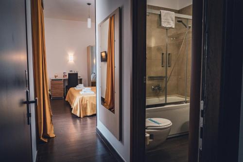 阿尔贝罗贝洛Hotel Majesty Alberobello的一间带卫生间和淋浴的浴室以及一张桌子