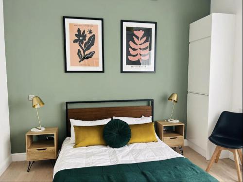伦敦Gorgeous split level Belsize Park Apartment的一间卧室配有一张带两张桌子和两盏灯的床。