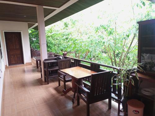 Ban Nahin-Nai (2)Phamarn View Guesthouse的门廊上的带桌椅的用餐室