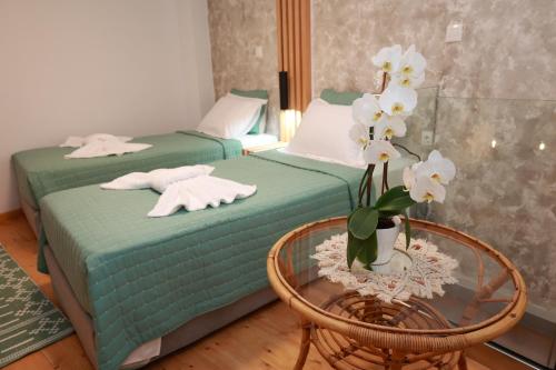 普洛马里翁Cane’s Family Guest House的配有两张床铺的带桌子和鲜花的房间